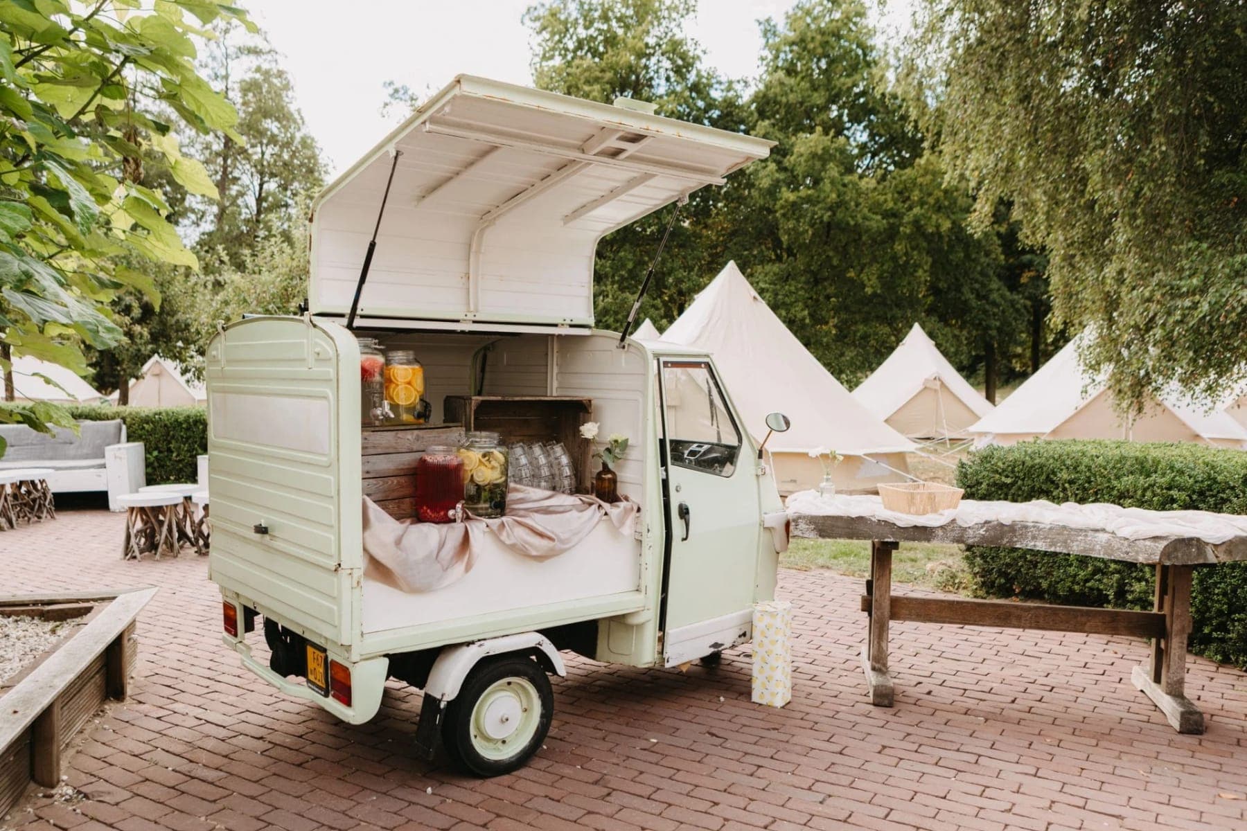 Mintgroene Piaggio-barwagen tussen de belltenten